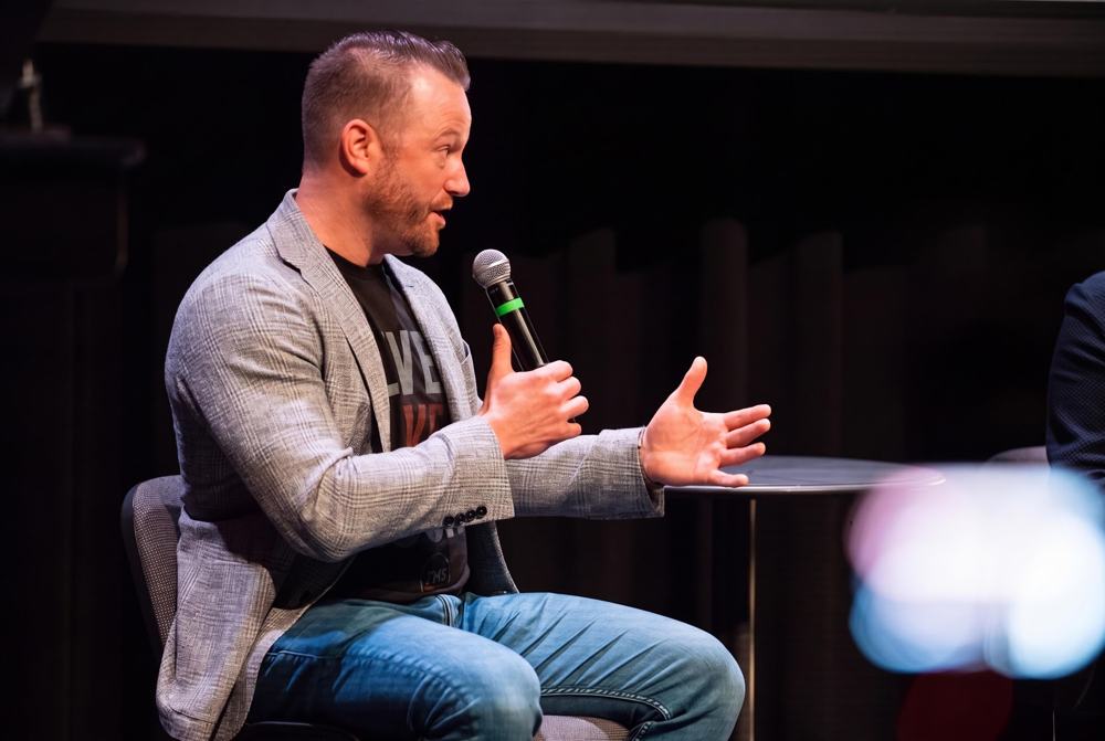 A speaker interviewed on stage at Thrive Not Survive X